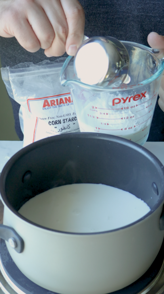 1. Start by measuring 2 cups whole milk. Pour one and half cups into a sauce pan.
2. Then the last half cup, mix with 1/3 cup corn starch.
3. Then add that into the sauce pan with the rest of the milk.